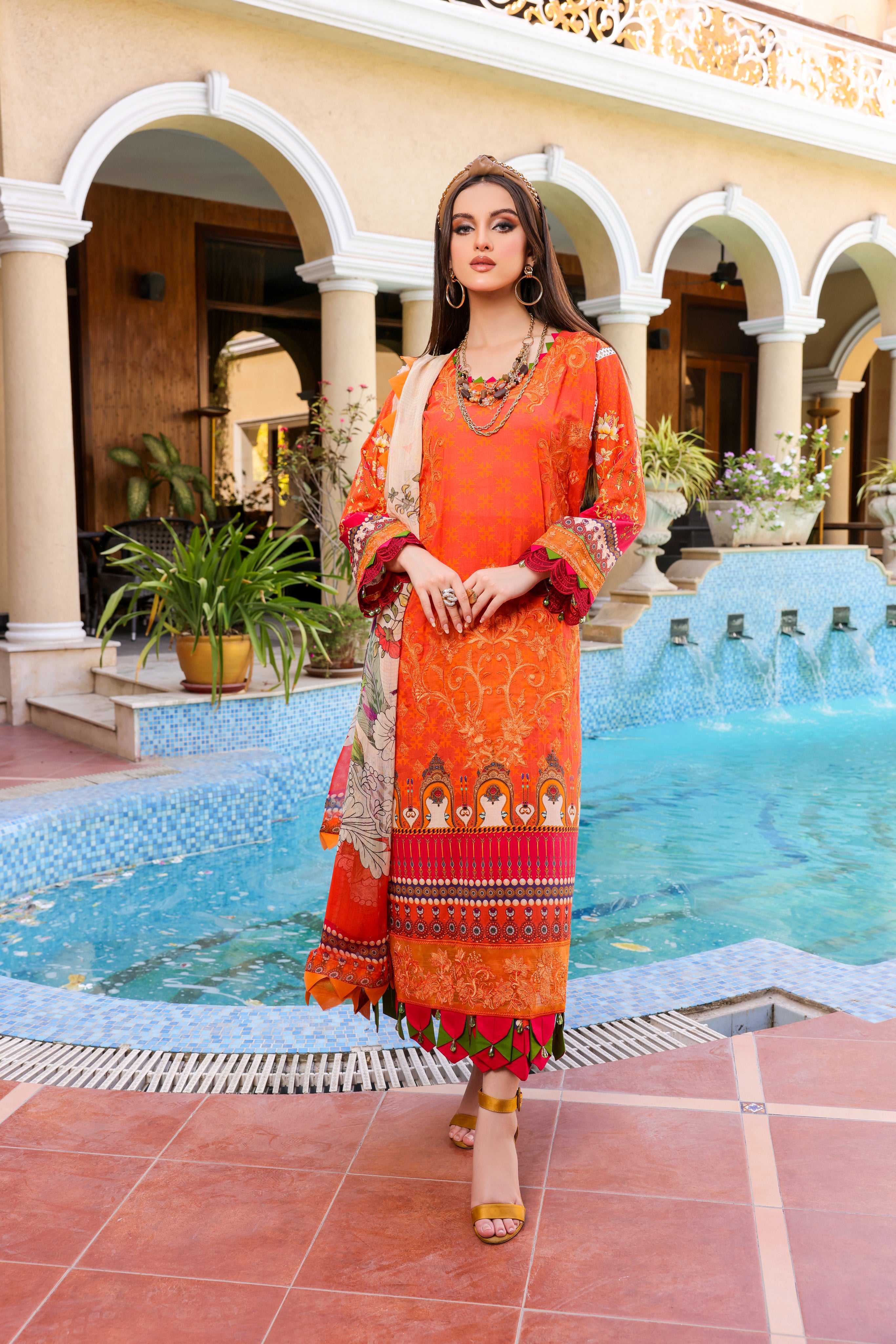 A girl is standing in front of a pool wearing a Embroidered Organza Suit.